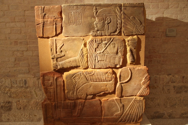 Blocs de grès sculptés provenant de la chapelle funéraire de Qore Amanitenmemide à Méroé, avec une image du souverain assis sur son trône protégé par Isi ailée, Ier siècle après J.-C. (Berlin, Neues Museum)