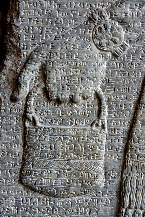 Rappresentazione di una situla con acqua lustrale di un apkallu e iscrizione reale di Assurnasirpal II, re d’Assiria, IX secolo a.C. Dettaglio da un bassorilievo in alabastro dal Palazzo di Nord-ovest di Nimrud, Iraq. Pergamon Museum, Berlino.